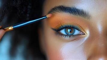 Close-up of a makeup brush applying color to an eyeshadow palette during a beauty routine photo