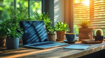 Bright indoor workspace with plants, coffee, and laptop in a sunny setting photo