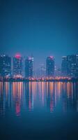 Stunning city skyline illuminated at night reflecting on water surface in urban area photo