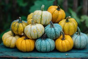 Colorful assortment of pumpkins arranged on a wooden table surrounded by garden foliage photo