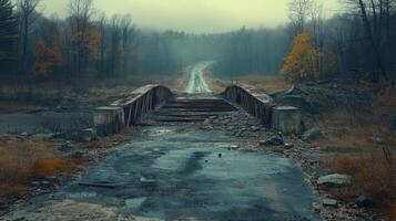 Abandoned road with collapsed bridge surrounded by autumn foliage on a rainy day photo