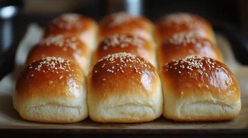 Freshly baked golden dinner rolls cooling on a tray in the kitchen photo