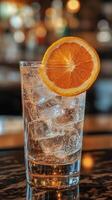 Refreshing drink garnished with orange slice on a sunny table surrounded by fresh oranges photo