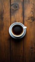 Rich black coffee served in a white cup on a rustic wooden table in a cozy setting photo