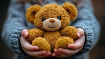 Child holding a soft teddy bear while sitting indoors in cozy sweater photo