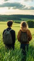 Couple enjoying a peaceful moment in lush green fields with mountains in the background photo