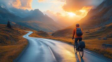 Cyclist enjoys sunset ride along winding road in mountainous landscape photo