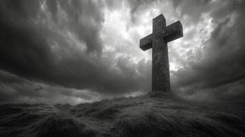 Celtic cross standing on a hill under dark stormy sky at dusk with dramatic clouds and moody atmosphere photo