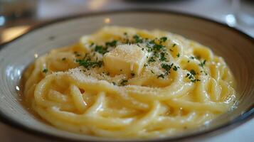 Creamy pasta dish topped with butter and parsley served in a restaurant setting photo
