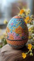 Beautifully decorated easter egg featuring intricate floral designs on wooden surface photo
