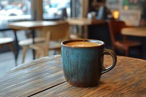 Warm latte served in a textured cup on a rustic wooden table in a cozy caf atmosphere photo