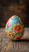 Beautifully decorated easter egg featuring intricate floral designs on wooden surface photo