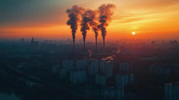 City skyline under orange sunset with smoke rising from buildings in a pollution-filled atmosphere photo