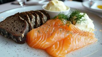 Freshly sliced salmon served with red onion and creamy dressing on a light plate photo
