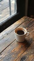 Warm coffee cup surrounded by autumn leaves and pinecones on wooden table photo