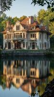 Majestic mansion reflected in serene waters surrounded by lush greenery in a tranquil setting photo