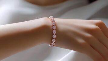 Elegant hand adorned with a triple strand pearl bracelet on silky fabric photo