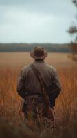 Soldier standing in a field during a sunny afternoon, contemplating the vast open landscape photo