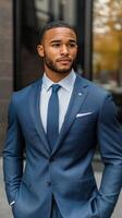 Confident man in elegant blue suit poses outside a modern building in the city photo