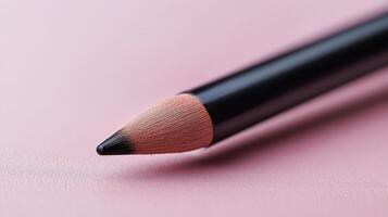 Pink lip pencil resting on a smooth layer of pastel pink makeup product photo