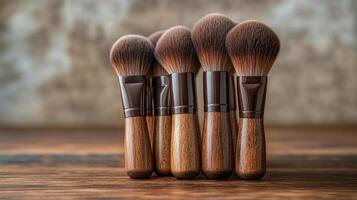 Variety of makeup brushes arranged neatly on a wooden surface near green plants photo