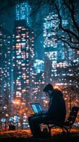 City dweller working on laptop at night in urban park with glowing skyscrapers photo