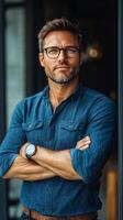 Confident man standing indoors wearing glasses and casual attire in a stylish environment photo