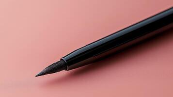 Pink lip pencil resting on a smooth layer of pastel pink makeup product photo