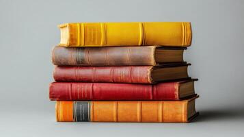 Stacked vintage books with various colors arranged neatly on a light surface photo