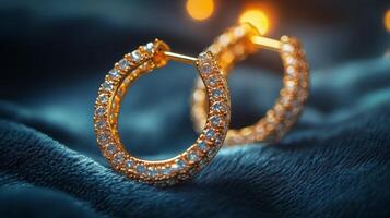 Elegant gold hoop earrings with sparkling gemstones on a textured textile background photo