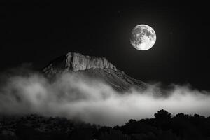 Majestic Mount Fuji under a bright full moon with clouds in the night sky photo