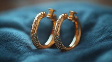 Elegant gold hoop earrings with sparkling gemstones on a textured textile background photo