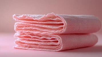 Soft pink towels stacked neatly on a pastel background for home dcor and relaxation photo