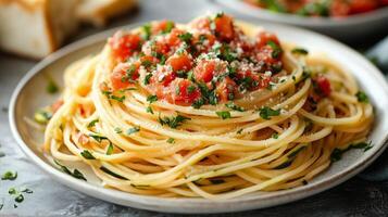 Classic spaghetti with fresh herbs and grated cheese on a dark plate photo