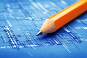 Close-up of orange pencil highlighting architectural blueprint in a creative workspace photo