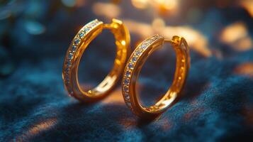 Elegant gold hoop earrings with sparkling gemstones on a textured textile background photo