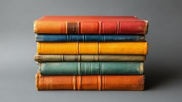 Stacked vintage books with various colors arranged neatly on a light surface photo