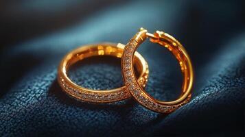 Elegant gold hoop earrings with sparkling gemstones on a textured textile background photo