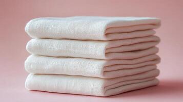 Soft pink towels stacked neatly on a pastel background for home dcor and relaxation photo