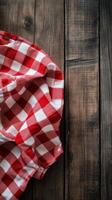 Red and white checkered cloth on rustic wooden table with fresh herbs nearby photo