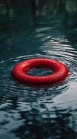 Red life ring floating serenely in clear blue water during a sunny day photo