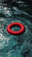 Red life ring floating serenely in clear blue water during a sunny day photo
