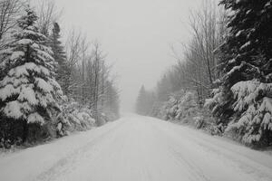 Winter road through a snowy landscape with mountains in the background under clear blue sky photo
