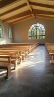 Empty classroom with wooden tables and natural light in a spacious layout photo