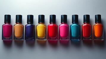 Colorful collection of vibrant nail polish bottles arranged in a neat line on a white surface photo