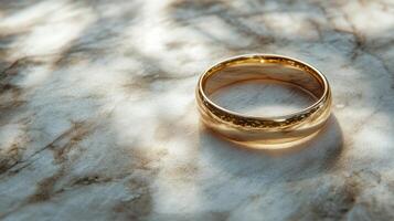 Golden ring resting on textured surface with soft light illuminating its polished finish photo
