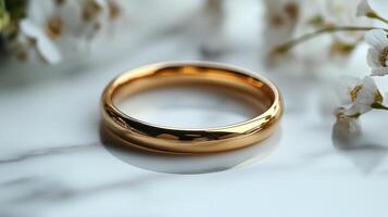 Golden ring resting on textured surface with soft light illuminating its polished finish photo