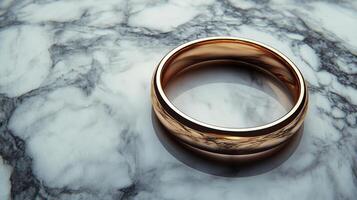 Golden ring resting on textured surface with soft light illuminating its polished finish photo