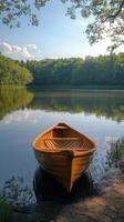 Canoe resting peacefully on the shore of a tranquil lake surrounded by lush green trees photo