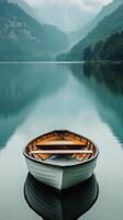 Tranquil wooden boat floating in serene foggy waters surrounded by lush forests photo